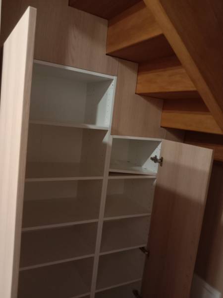 Conception d'un aménagement sous un escalier dans une maison à Manéglise